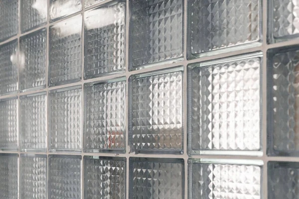 Şeffaf cam bloklar modern bir duvar oluşturarak ışığın boşluğa desen ve derinlik ekleyerek geçmesine olanak sağlıyor. Tasarım, geometrik şekillerle atmosferi güçlendirir..