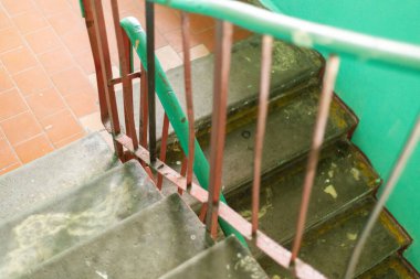 Eski bir evdeki merdiven yıpranmış ve hasar görmüş. Boya soymak ve bir zamanlar canlı olan bu evde yıllarca süren ihmalkârlık. Yeşil duvarlar terk edilme duygusunu arttırır..