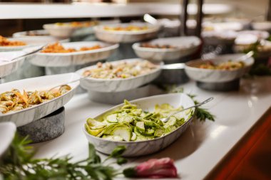 Çeşitli taze salatalar ve mezeler bir büfede mermer servis kaselerinde güzelce düzenlenir. Misafirler renkli sebzelerden ve lezzetli seçeneklerden birini seçebilirler..