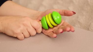 Renkli ahşap bir çıngırak palmiyeye çarptığında yüksek bir ses çıkarır. Ritim sesi atmosfere neşe katıyor, müzik veya eğlence ortamlarında eğlenceli kullanımını gösteriyor