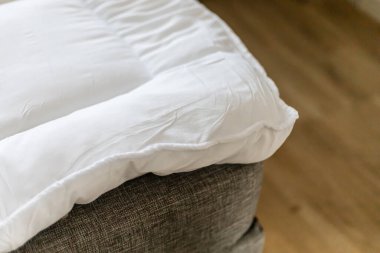 Kanepede uzanmış bir yatak örtüsü kanepede uyuyan biri için ekstra rahatlık sağlıyor. Dekor ahşap zemini olan bir oturma odasında, dinlenmek için basit bir yer yaratıyor..