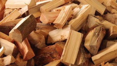 Yakacak odun bir depodaki ahşap yığının içine teker teker düşer. Bu etkinlik, istifleme sürecine odaklanarak gün ışığında açık gökyüzü altında gerçekleşir..