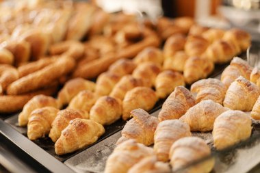 Bir tepside çeşitli yeni pişmiş hamur işleri bulunur. Fırıncının çalışmalarını gösteren farklı şekil ve boyutlarda düzenli bir şekilde düzenlenir. Sabahları fırın gibi oluyor..