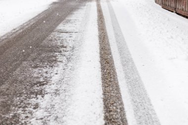 Bir yol karla kaplıdır ve açık lastik izleri gösterir. Çevrede kar yağmamış. Bu da yeni kar yağdığını gösteriyor. Kış geldi..