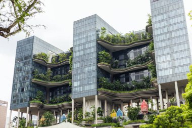 Singapur - 7 Ocak 2026: Singapur 'daki yüksek binalar çeşitli seviyelerde yeşillik içerir. Tasarım doğayı kentsel çevreye entegre eder. Sahne, hareketli bir şehirde hayat yakalıyor..