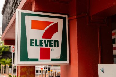 Singapur - 25 Ocak 2026: 7 Eleven Shop adında bir market Singapur 'da işlek bir caddede görülebilir. Parlak dükkan levhasında yedi numara ve marka ismi görünüyor..