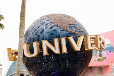 Singapur - 25 Ocak 2026 Universal Stüdyoları Singapur 'da kalabalık toplandı. İnsanlar güneş batarken fotoğraf çeker ve çekimlerini keşfederler. Büyük küre herkesin görmesi için girişte duruyor..