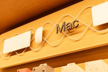 Singapur - 27 Ocak 2026: Müşteriler Mac ürünleri ve aksesuarlarını keşfetmek için Singapur 'daki Apple Store' u ziyaret ederler. Ekran, müşteriler gezinirken ahşap bir raftaki bir klavye ve fareyi vurgular.