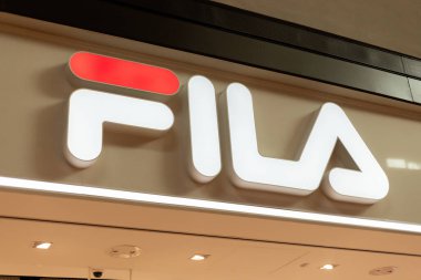 Singapur - 27 Ocak 2026: Fila mağaza tabelası Singapur 'daki bir alışveriş merkezinde açıkça görülüyor. Alışverişçiler, kalabalık alışveriş alanındaki farklı mağazaları ve markaları kontrol ederken etrafta dolanıyorlar..