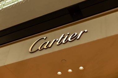 Singapur - 27 Ocak 2026: Lüks bir mağaza tabelası, Singapur 'da işlek bir alışveriş bölgesinde Cartier markasını gösteriyor. Öğleden sonra güneş etrafı aydınlatırken müşteriler geçiyor..