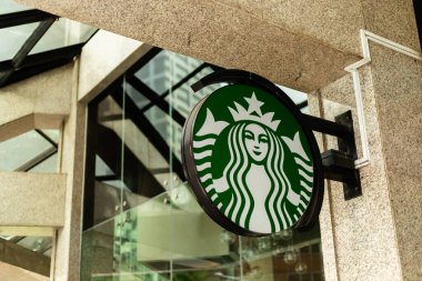 Singapur - 27 Ocak 2026: Starbucks Kahve tabelası Singapur 'da bir mağazanın önünde asılı. Mekan modern mimariyi ve günlerini yaşayan insanlarla dolu bir alanı gösteriyor..