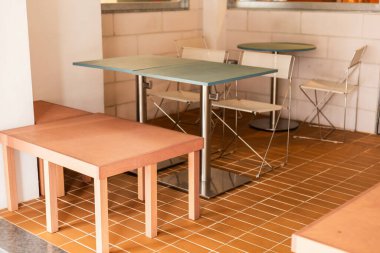 Bir kafe içi masa ve sandalyelerle basit bir düzeneğe sahiptir. Bu alan döşeme döşemeleri ve en az dekorasyon ile kaplanmış, sıradan bir yeme alanı oluşturuyor..