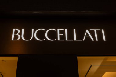 Singapur - 27 Ocak 2026: Buccellati 'nin parlak işareti Singapur' daki mağazasının önünde parlıyor. Müşteriler akşamları lüks markaların önünden geçerler. Bölge insanlarla dolu..