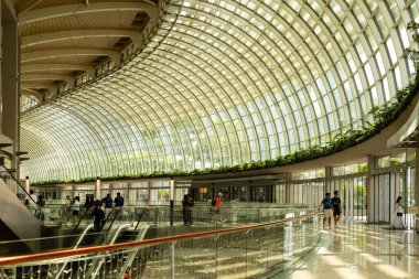 Singapur - 27 Ocak 2026: İnsanlar Singapur 'daki Marina Bay Sands' de Shoppes 'in içinde yürürken görülüyor. Büyük cam yapı, ziyaretçiler dükkanları keşfederken boşluğu bol bol aydınlatmaya olanak sağlıyor..