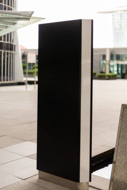 Şehir merkezine üzerinde metin ya da bilgi olmayan boş bir tabela yerleştiriliyor. Arka planda binalar ve açık bir gökyüzü görülebilir..