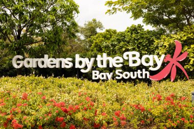 Singapur - 11 Ocak 2026: Ziyaretçiler, Singapur 'un güneyindeki Körfez Koyu' nun yanındaki Bahçeler 'in giriş işaretinde toplandılar. Bahçede çeşitli bitkiler ve çiçekler yer alıyor. Çevre yeşillikle çevrili.