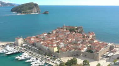 Küçük bir Adriyatik kasabasının marinasının üzerinde uçmak, yat ve teknelerin havadan görüntüsü. Budva, Adriyatik denizi, Karadağ