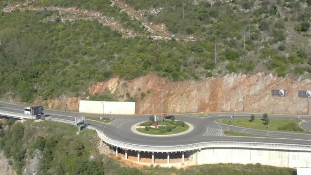 Budva, Montenegro, 22. Oktober 2020: Kreisverkehr auf der Stadtautobahn. Autos, Busse und Lastwagen fahren auf einer viel befahrenen Autobahn in einer Stadt. Seitenhieb auf fahrenden Bus: Viele Autos bewegen sich auf einer Straße