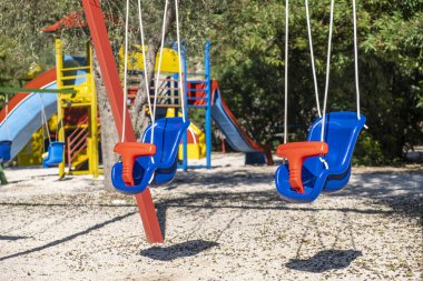 Covid-19 nedeniyle kapalı olan bir anaokulundaki çocuk parkında boş salıncak.