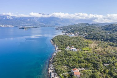 Sonbaharda Karadağ 'ın küçük bir kasabası olan Adriyatik kıyı şeridinin hava fotoğrafı. Güneşli bir gün, mavi gökyüzü, uzaklardan görünen dağlar. Denizde su turkuazdır, saf ve berrak.