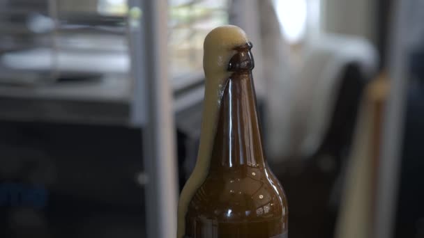 满满一瓶黑啤酒 泡沫从瓶子的颈部流出 — 图库视频影像