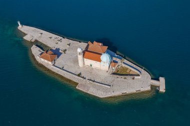Hava görüntüsü, insansız hava aracı turnuva denizinin üzerinde uçuyor. Küçük adanın üzerinde. Bir adada Hristiyan tapınağı var.