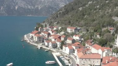 Karadağ 'ın deniz kenti havadan izleniyor. Denizin ve kıyı şeridinin üzerinde uçuyor. Antik Balkanlar geleneksel mimari beyaz taş binalar kırmızı çatılar, antik Hıristiyan kilisesi ve arka planda dağlar