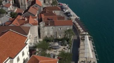 Karadağ 'ın deniz kenti havadan izleniyor. Denizin üzerinde alçaktan uçuyor ve kasabanın sahil şeridi boyunca uçuyor. Antik Balkanlar geleneksel mimari kırmızı çatılı beyaz taş binalar, antik Hıristiyan kilisesi 