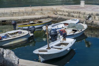 Küçük balıkçı tekneleri, güneşli yaz günlerinde balıkçı tekneleri ve ağlarla rıhtıma demirlemişti.