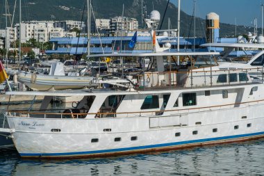 Bar, Karadağ, 18 Haziran 2021: Monthe Town Bar marinası manzarası. Limandaki iskeleye demirlemiş motorlu tekneler, lüks yatlar ve gemiler. Dağlar arka planda görünür.