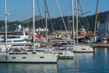 Bar, Karadağ, 18 Haziran 2021: Monthe Town Bar marinası manzarası. Limandaki iskeleye demirlemiş motorlu tekneler, lüks yatlar ve gemiler. Dağlar arka planda görünür.