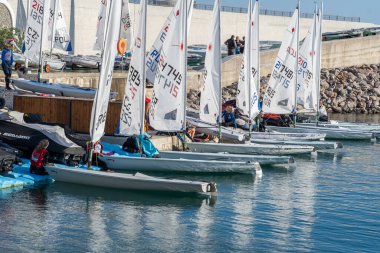 Lustica Körfezi, Karadağ, 14 Haziran 2021: İlk Avrupa Denizcilik Şampiyonası. Rıhtımdaki yelkenli ve motorlu tekneler, farklı ülkelerden takım üyeleri bir yelkencilik hazırlığı içindeler.