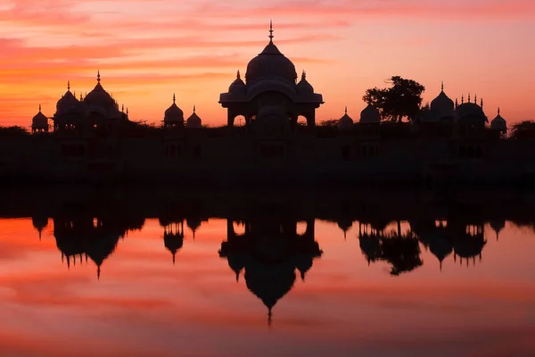 Kusum Sarovar, kırmızı günbatımında. Hindistan 'ın Uttar Pradesh ilçesi Mathura' da Mansi Ganga ve Radha Kund arasındaki kutsal Govardhan Tepesi 'nde bulunan tarihi bir kumtaşı anıtı.