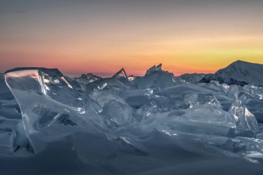 Baykal Gölü 'nün kristal buzunun üzerinde renkli bir günbatımı. Sibirya, Rusya
