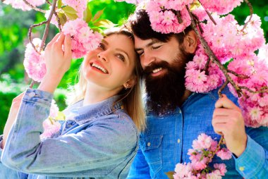 Bahar çifti Sakura ağacının yanında. Çiçek açan bahçede mutlu bir aile.