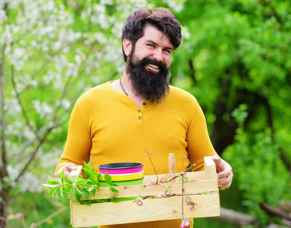 春の庭。植え付けの準備をしている笑顔の男。庭で働いている。庭師の仕事. — ストック写真