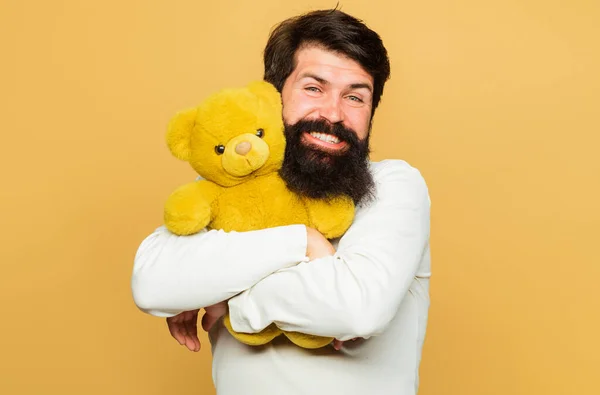 Smiling man hugs Teddy bear. Gift and present. Happy man with plush toy. Birthday Celebration.