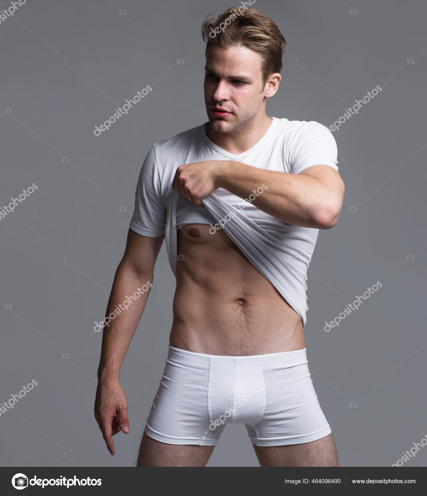 Handsome man in underweare. Sexy macho take off t-shirt. Mens