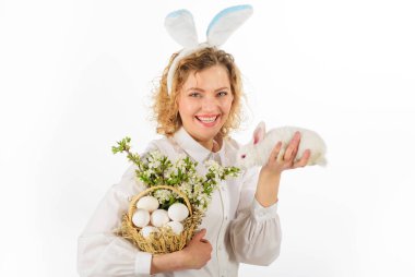 Mutlu Paskalyalar. Sepet yumurtalı gülümseyen kız ve Paskalya tavşanı. Yumurta avı.