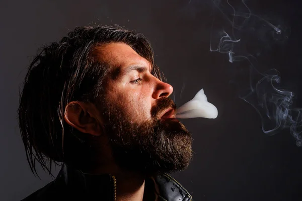 タバコを吸ってる。残酷な髭を生やした男がタバコを吸う。タバコの煙だ。タバコ. — ストック写真