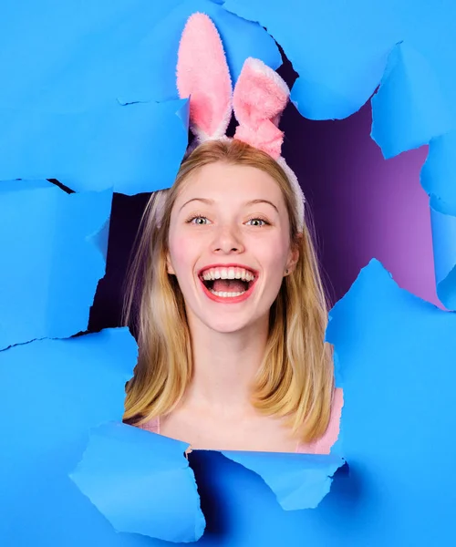 Joyeuse fête de Pâques. Femme souriante avec des oreilles de lapin regardant à travers le papier. — Photo