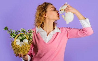 Sepet yumurtalı ve tavşanlı Paskalya kadını. Din. Yumurta avı. Mutlu Paskalyalar..