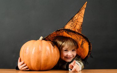 Cadılar Bayramı. Seni işaret eden balkabaklı cadı şapkalı çocuk. Şaka mı şeker mi?.