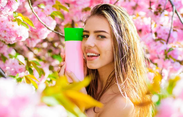 Beautiful woman with shampoo, balsam or conditioner. Smiling girl with Cosmetic for hair. — Stock Fotó