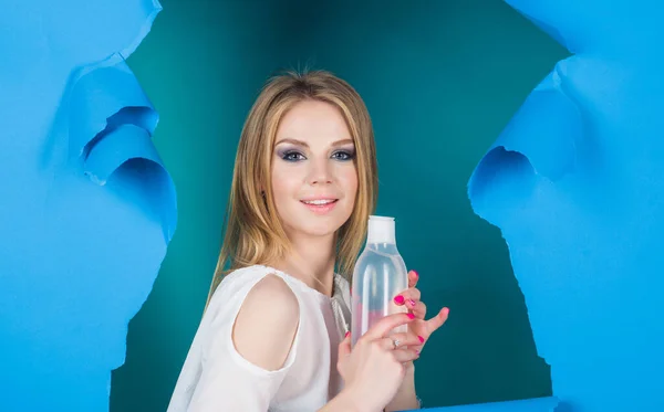 Женщина с бутылкой мицеллярной воды. Снятие макияжа. Обезжиренная. Косметические процедуры. — стоковое фото