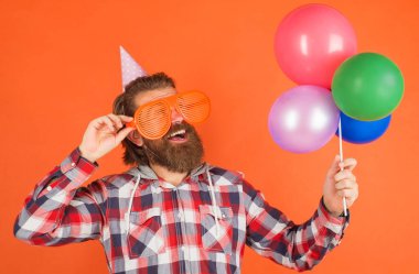 Parti zamanı. Balonlu ve parti gözlüklü mutlu sakallı adam. Tatiller ve kutlamalar.
