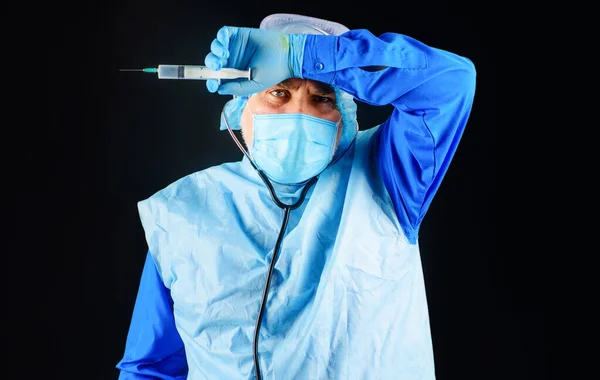 Aşılama. Koruyucu giysili doktor, tıbbi maske, şırıngalı güvenlik gözlüğü. Erkek hemşire iğneye hazırlanıyor.. — Stok fotoğraf