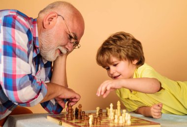 Child boy developing chess strategy. Grandfather and grandson playing chess. Brain development and logic concept.