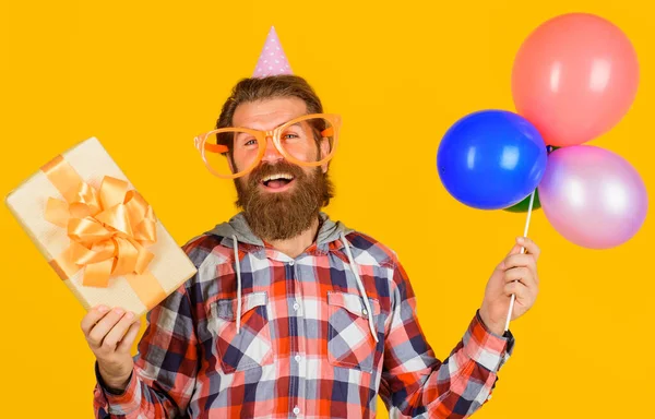 Celebration concept. Smiling man with present box and balloons. Happy birthday. Holidays and party. — Stok fotoğraf