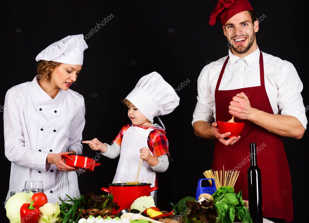 Happy family in kitchen. Parents with son preparing dinner. Healthy food at home. Homemade food.